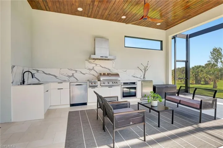 View of patio / terrace with exterior kitchen, outdoor lounge area, a grill, a lanai, and a sink