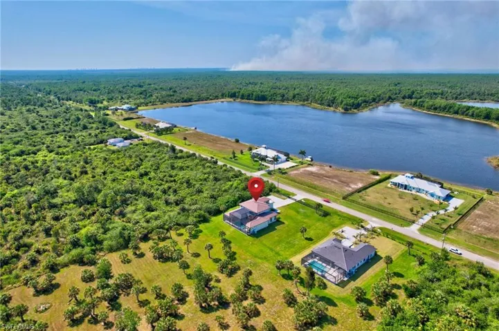 Birds eye view of property with a wooded view and a water view
