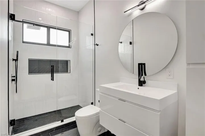 Full bathroom with vanity, a stall shower, and toilet