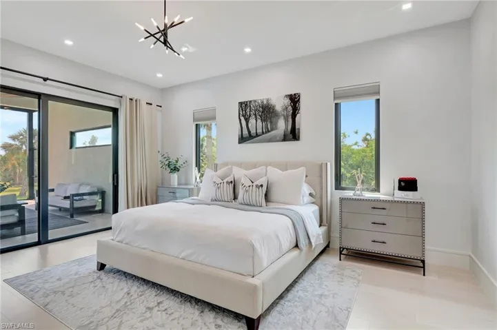 Bedroom with multiple windows, access to outside, a chandelier, and recessed lighting