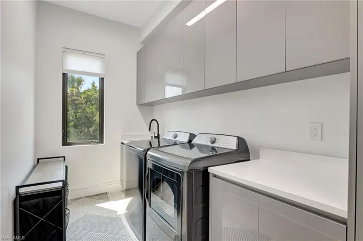 Laundry area featuring carpet floors, washer and clothes dryer, baseboards, and cabinet space