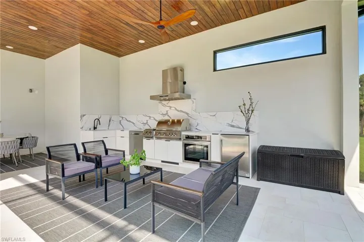 View of patio / terrace featuring an outdoor kitchen, ceiling fan, an outdoor hangout area, a grill, and a sink