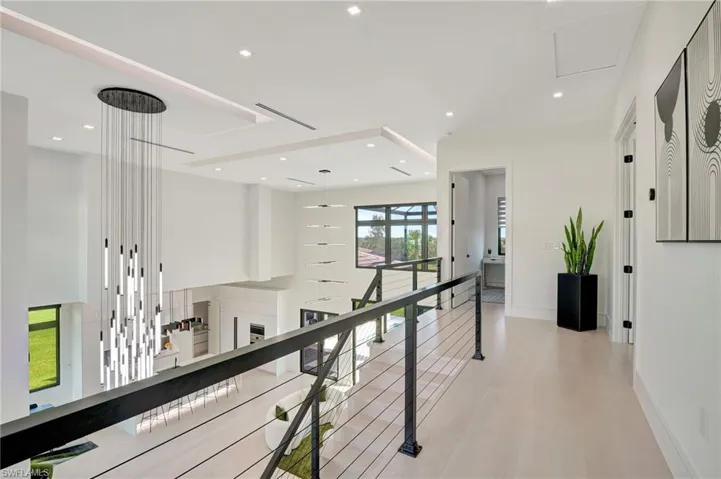 Hall featuring light wood-style floors, baseboards, an upstairs landing, and recessed lighting