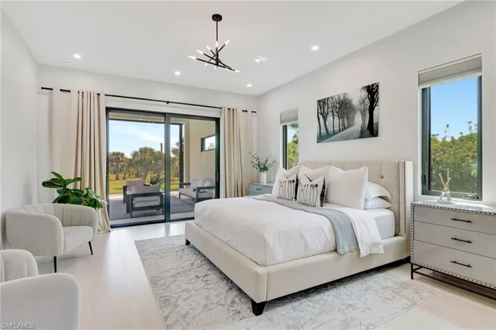 Bedroom featuring a chandelier, access to exterior, multiple windows, and recessed lighting