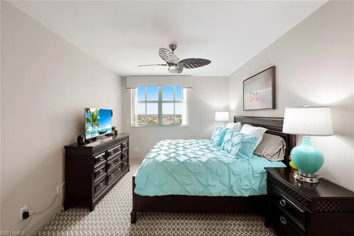 Carpeted bedroom with baseboards and a ceiling fan