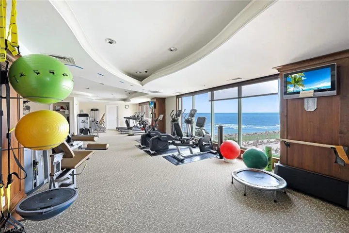 Workout area featuring visible vents, carpet flooring, and a wall of windows