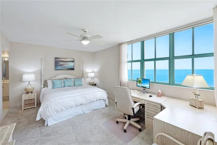 Bedroom with a ceiling fan, baseboards, and light colored carpet