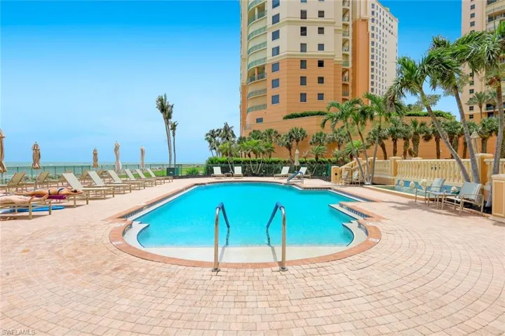 Community pool featuring a patio and fence