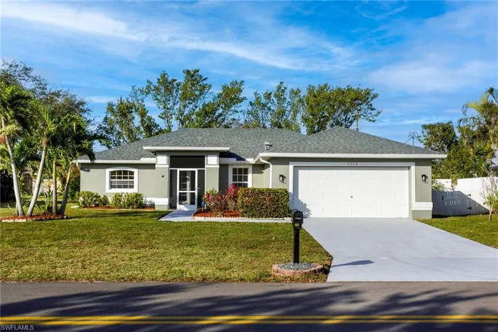 Ranch-style house featuring a front lawn and a garage