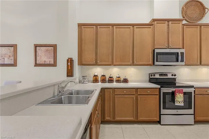 Kitchen with appliances with stainless steel finishes, light tile patterned floors, and sink