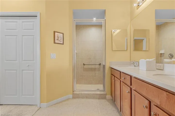 Bathroom featuring tile patterned floors, an enclosed shower, and vanity