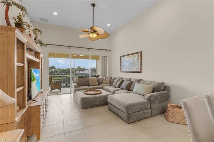 Tiled living room with a high ceiling and ceiling fan