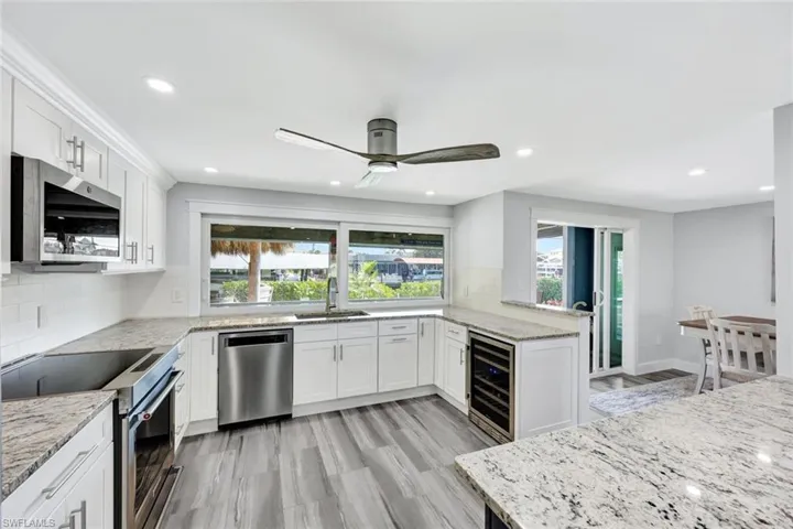 Kitchen features shaker cabinets and stainless appliances.
