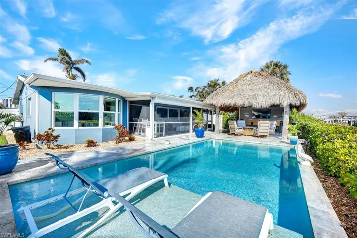 This backyard is TRULY an OASIS..featuring a bar AND tiki hut.
