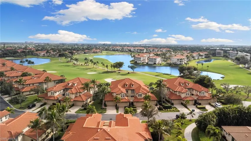 Aerial view of residential area featuring a nearby body of water and a golf club