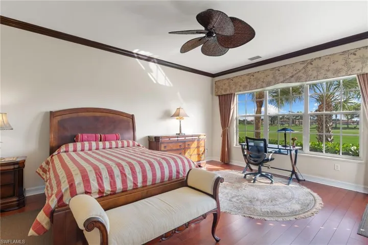 Bedroom featuring hardwood / wood-style floors, crown molding, and ceiling fan