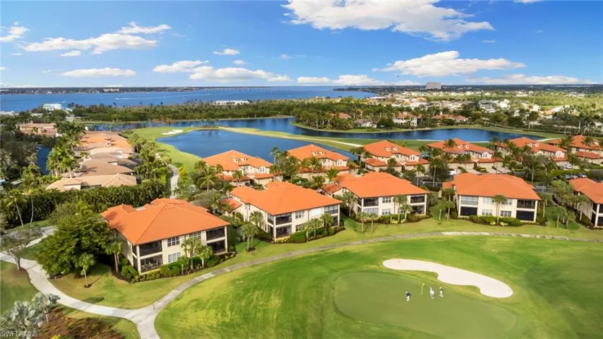 Aerial perspective of suburban area featuring a large body of water and a local golf course