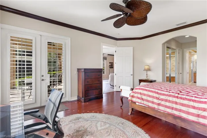 Bedroom with access to outside, dark wood-style flooring, crown molding, a ceiling fan, and a desk