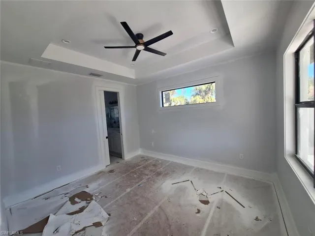 Spare room with ceiling fan and a raised ceiling