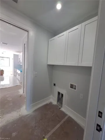 Washroom featuring hookup for a washing machine, electric dryer hookup, and cabinets