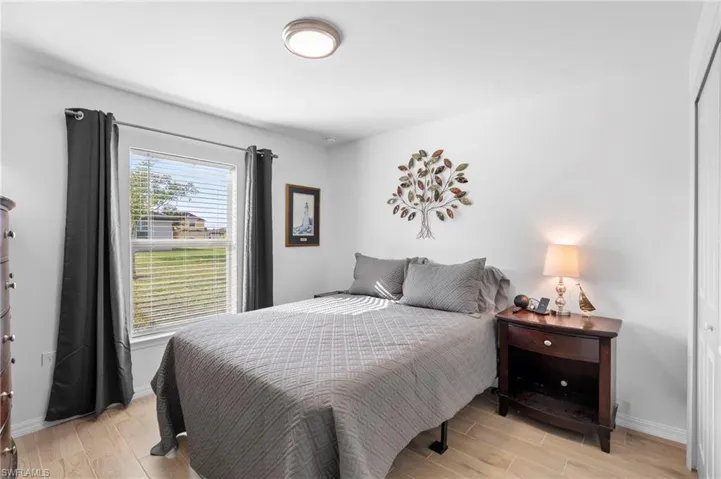 Bedroom with wood tiled floors and a closet