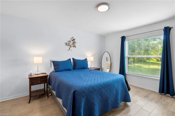 Bedroom with wood tiled floors and baseboards