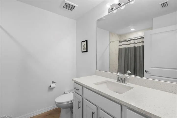 Bathroom with a shower with curtain and vanity