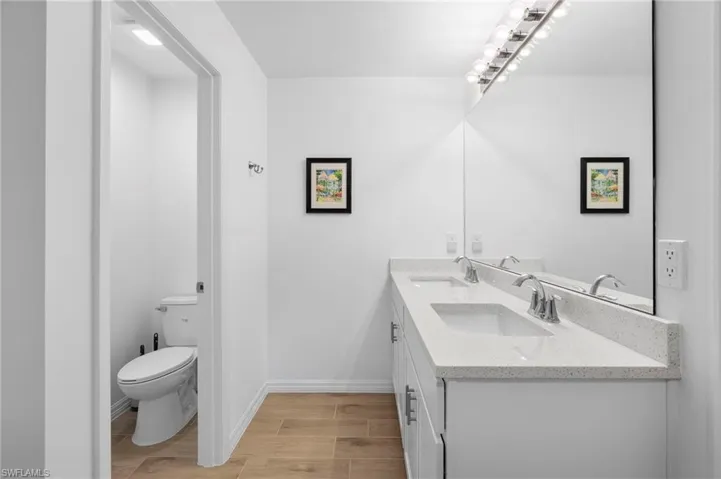 Full bath featuring double vanity and wood tiled floors