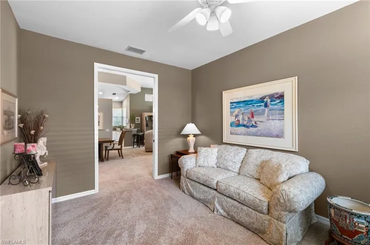 Carpeted living room featuring ceiling fan