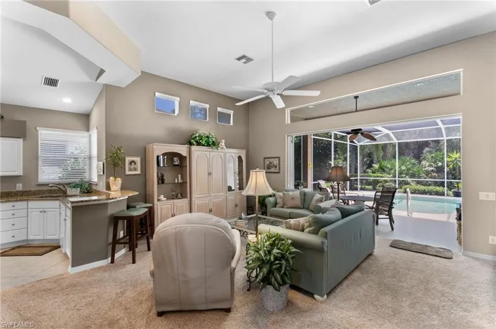 Living room featuring ceiling fan, a healthy amount of sunlight, and light colored carpet