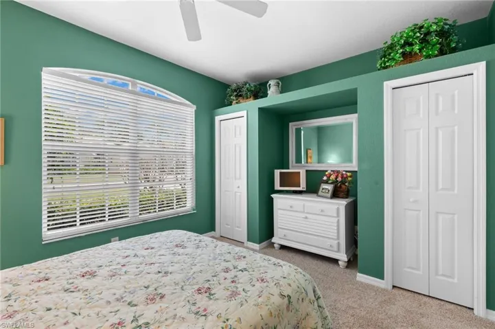 Bedroom featuring multiple closets, ceiling fan, and carpet floors