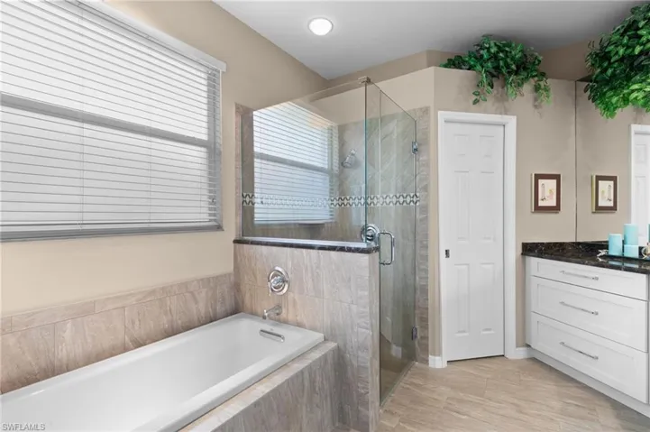 Bathroom with tile flooring, independent shower and bath, and vanity