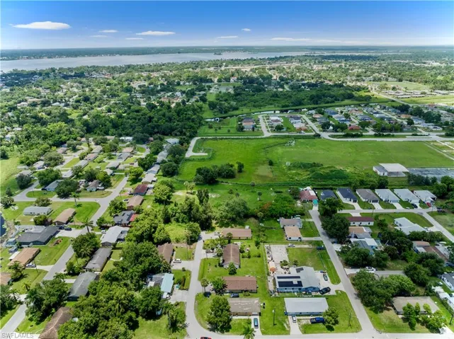 Aerial view of property and surrounding area with a nearby body of water and nearby suburban area