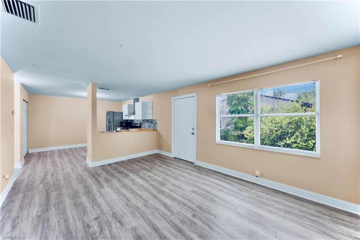 Unfurnished living room with light wood finished floors and baseboards