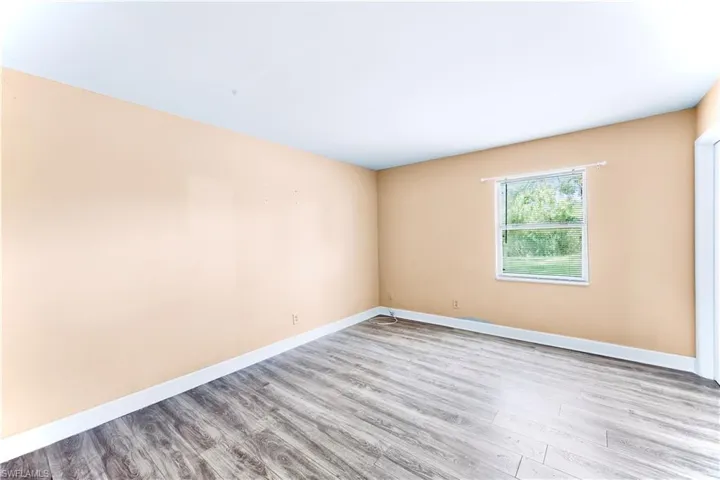 Spare room featuring wood finished floors and baseboards