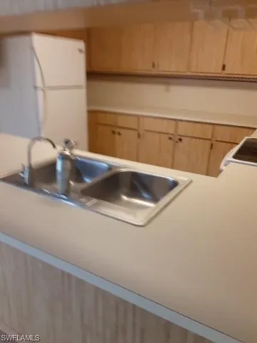 cabinetry, a sink, and light countertops