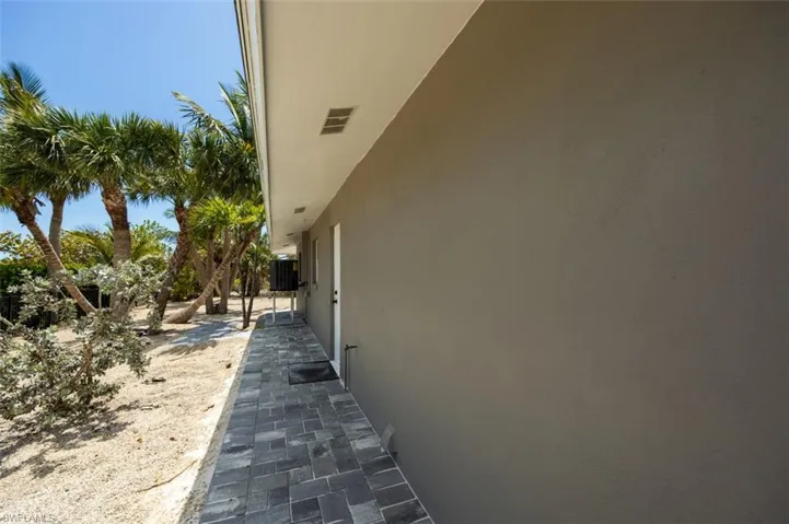 View of side of property featuring central AC and stucco siding
