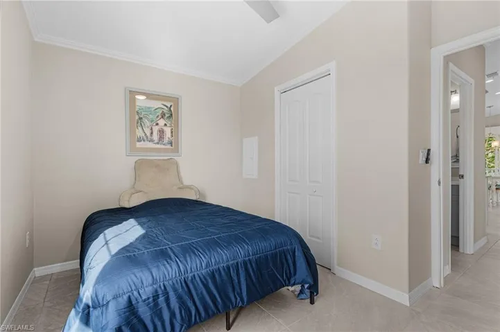 Bedroom featuring light tile floors, a closet, and ornamental molding