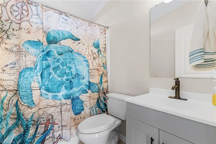Bathroom featuring toilet, vanity, and tub/shower combo