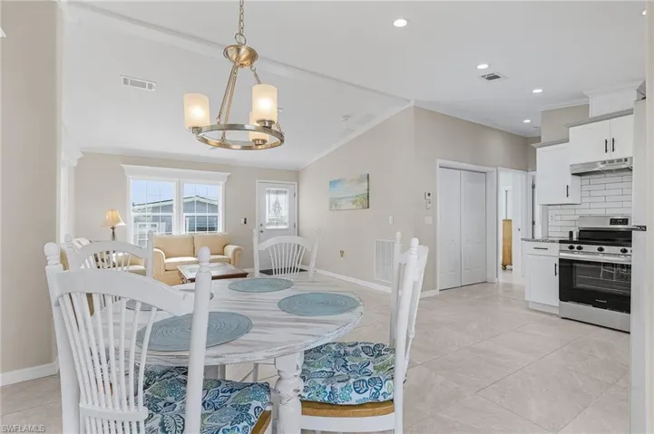 Dining area featuring lofted ceiling, crown molding, tile floor with open concept