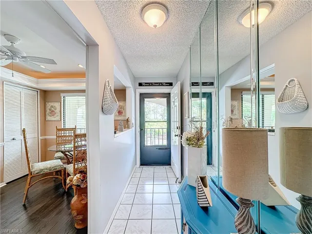Doorway to outside with tile floors, a textured ceiling, and ceiling fan