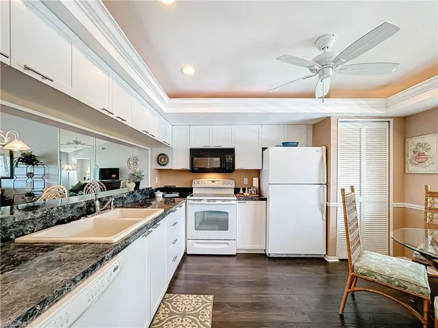 Kitchen featuring ceiling fan, dark hardwood / wood-style flooring, white appliances, and crown molding