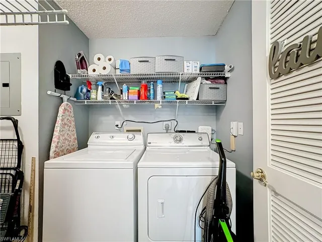 Laundry room with separate washer and dryer, washer hookup, and a textured ceiling