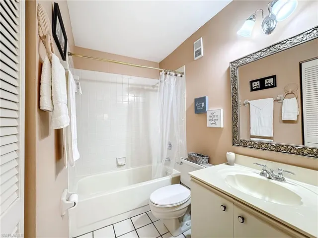 Full bathroom with shower / tub combo, tile flooring, toilet, and large vanity