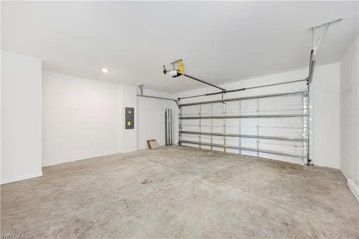 Garage featuring electric panel and a garage door opener