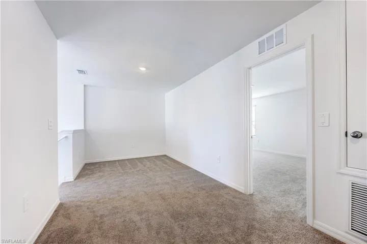 Spare room with light carpet and baseboards
