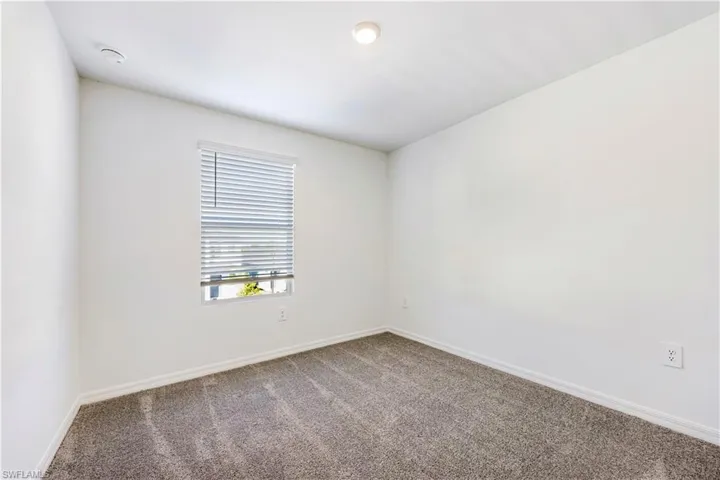 Carpeted empty room with baseboards