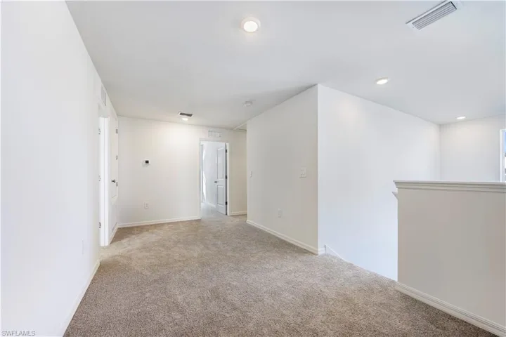 Empty room featuring light colored carpet and recessed lighting