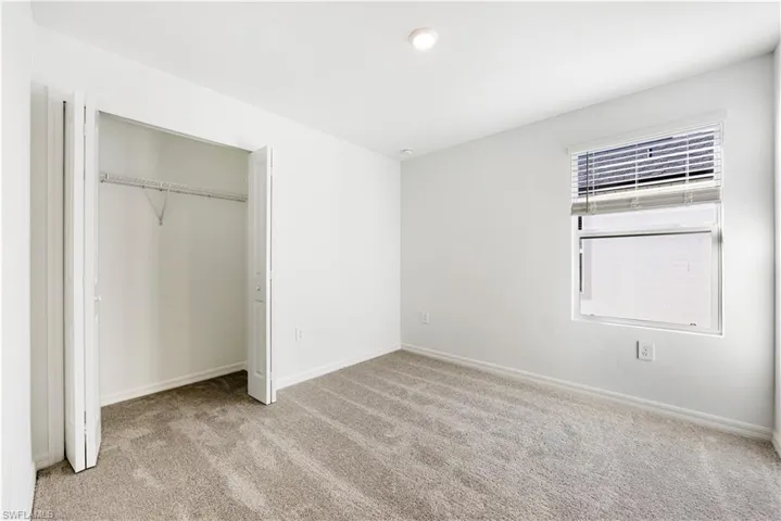 Unfurnished bedroom featuring light colored carpet, a closet, and recessed lighting