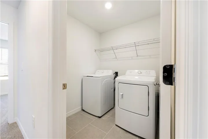 Laundry room featuring light tile patterned flooring and independent washer and dryer